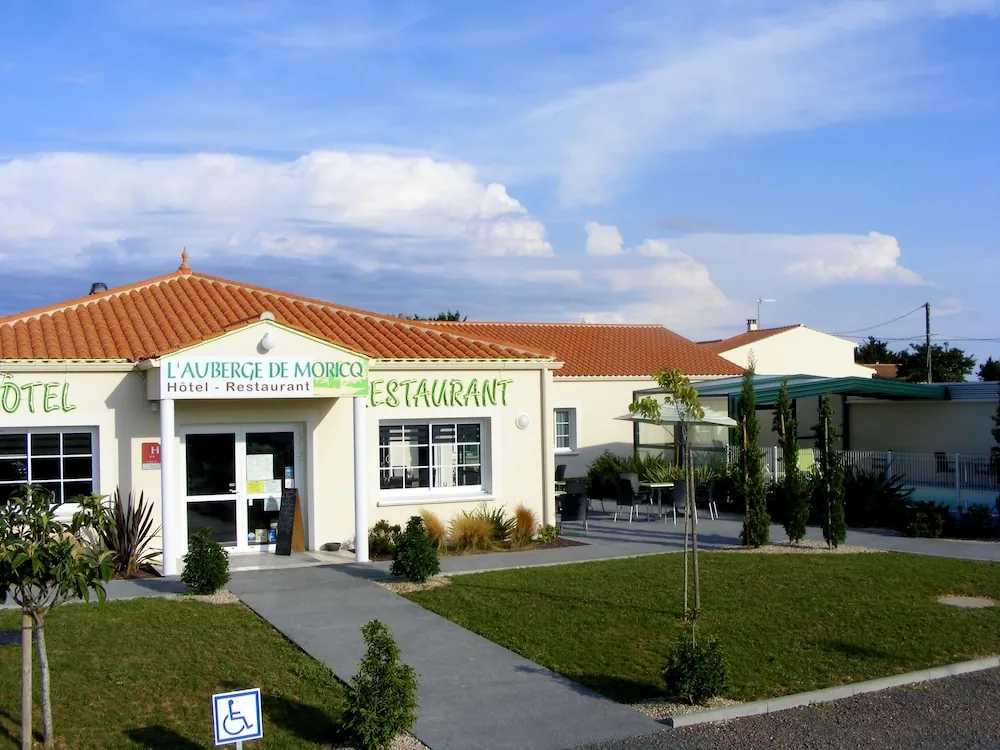 Façade de L’Auberge de Moricq à Angles : bâtiment de plain-pied au toit de tuiles, enseigne hôtel restaurant et allée fleurie