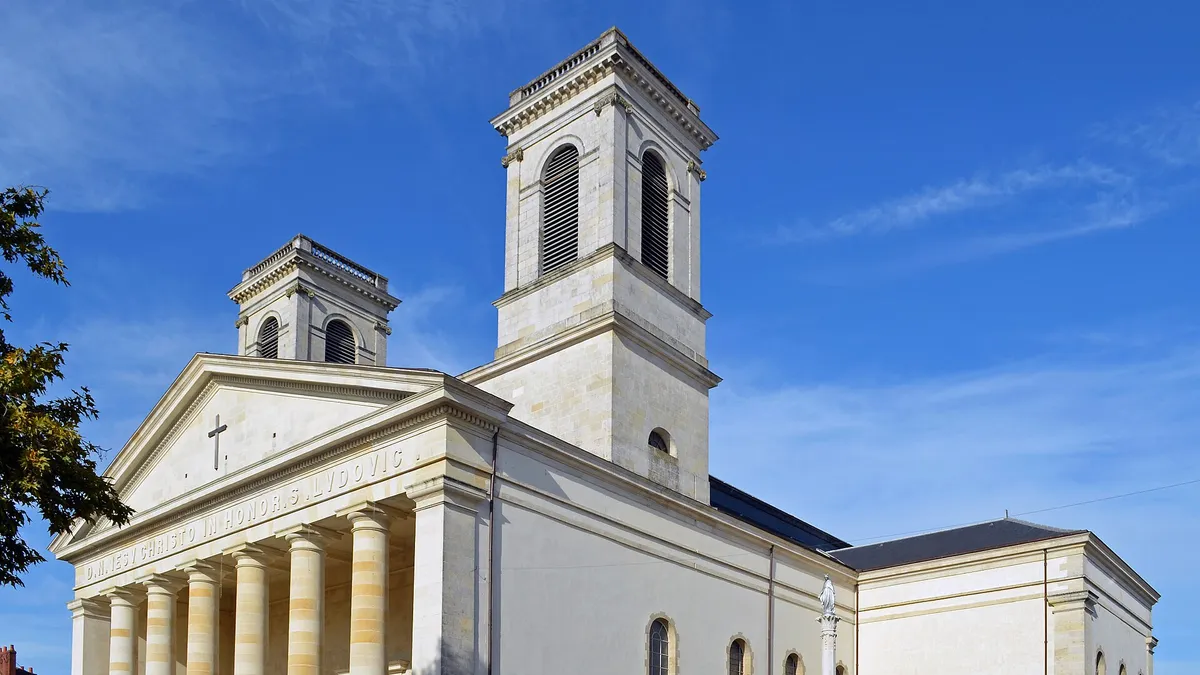 Façade à colonnes et clochers de l'église Saint-Louis, sous un ciel bleu, à La Roche-sur-Yon