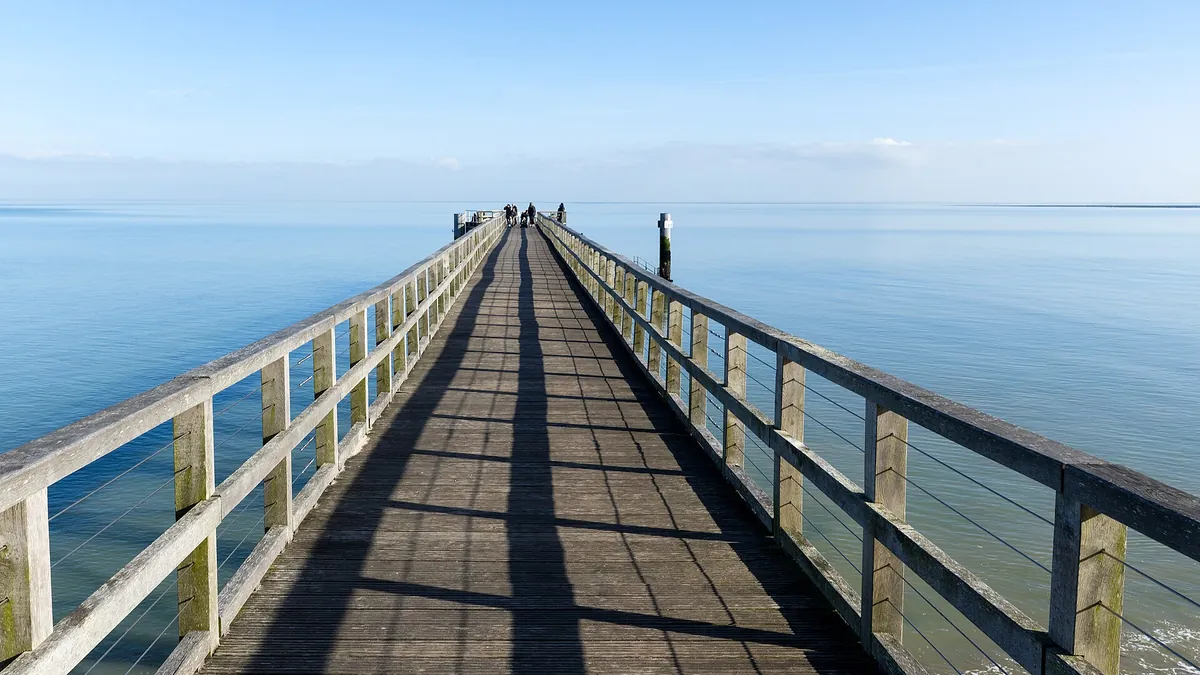 Longue estacade en bois qui s'avance sur une mer calme et bleue, à la plage des Dames de Noirmoutier-en-l'Île