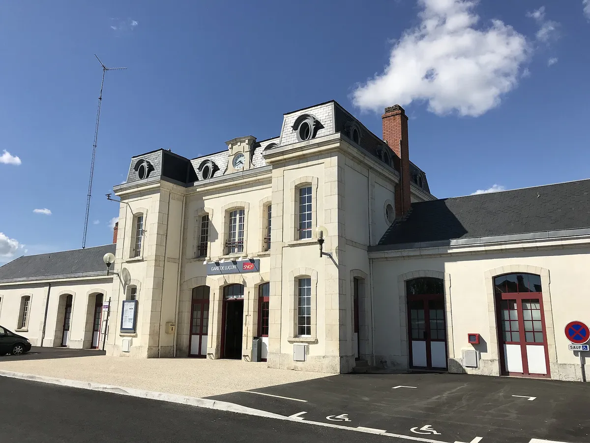 Bâtiment voyageurs de la gare de Luçon, en pierre claire avec des toits d'ardoise, sous un ciel bleu