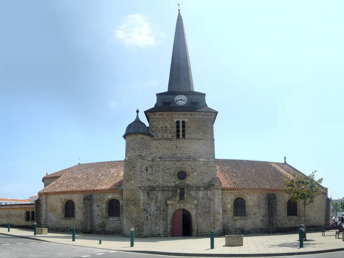 Église Saint-Jean-Baptiste de Saint-Jean-de-Monts, avec son clocher à flèche et sa tourelle, sur une place du centre-ville