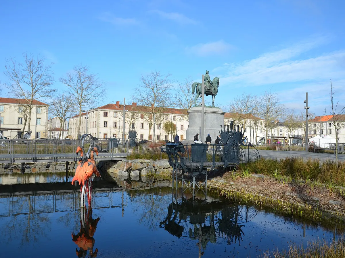 Bassin de la place Napoléon à La Roche-sur-Yon, avec un flamant rose mécanique au premier plan et la statue équestre de Napoléon au fond